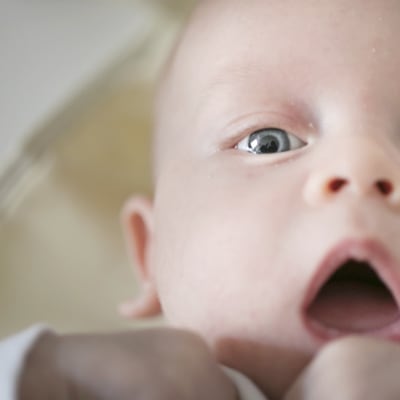 Vauva katsoo kameraan suu auki.