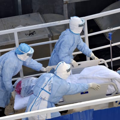 Koronaviruspotilasta siirretään sairaalan sisään Kiinan Wuhanissa 4. helmikuuta 2020.