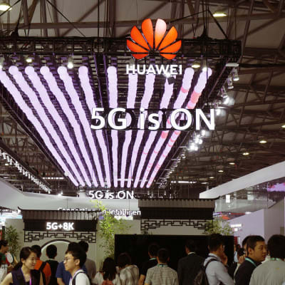 Messuvieraat tutkivat Huawein 5G-puhelimia Shanghaissa.