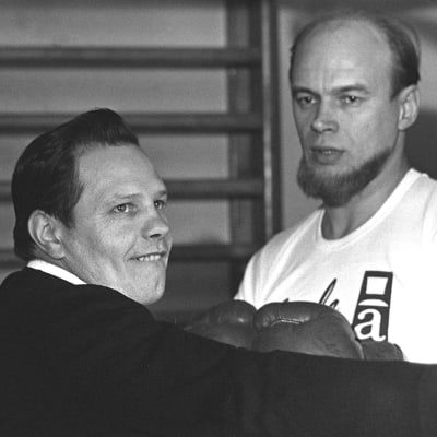 Elis Ask demonstrerar för Spede Pasanen grunderna i boxning. Året är 1965