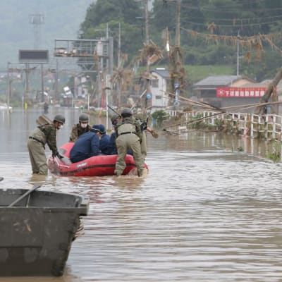 Japanin puolustusvoimat ja poliisi pelastamassa hoitokodin asukkaita tulvan keskellä.