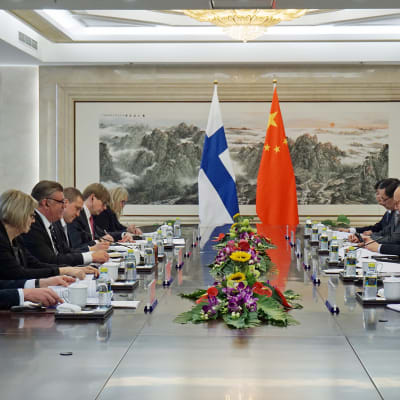 Peking Soini ja Wang neuvottelupöydässä.