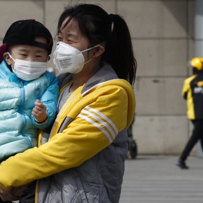 Äiti ja lapsi suojasivat kasvojaan ilmansaasteilta Pekingissä.