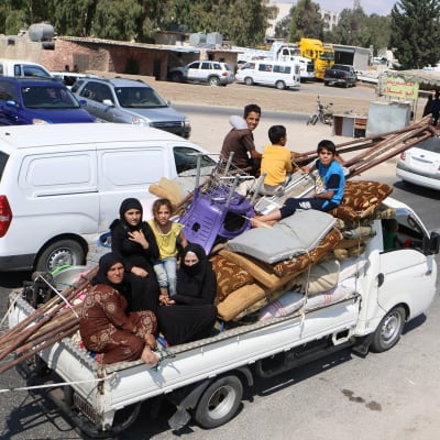 Siviilit pakenevat Idlibin maakunnassa Syyriassa, auton lavalla seitsemän ihmistä, patjoja ja huonekaluja.
