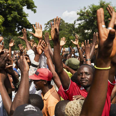 Kongolaisia miehiä kädet pystyssä.
