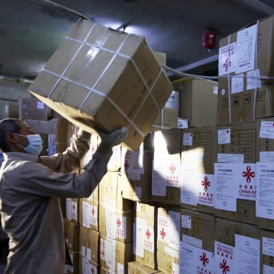 Kiinasta tuotua lääkintätarvikekeiden erää puretaan Damaskoksessa.