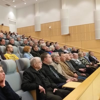 Ihmisiä auditoriossa