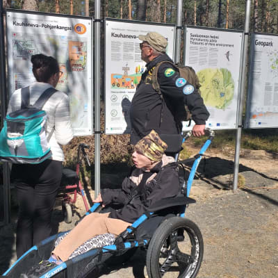 Ihmisiä opastaulua lukemassa