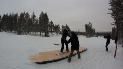 Kvinna gör snowboardtricks och glider på en ramp