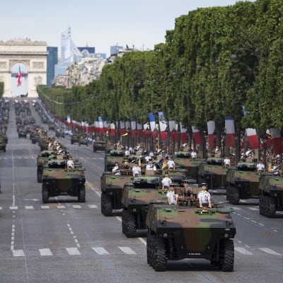 Ranskalaisjoukkoja ja panssariajoneuvoja kadulla. Taustalla riemukaari.
