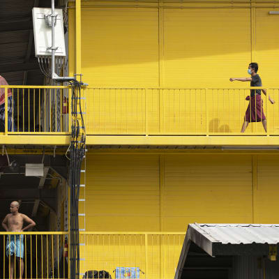 Siirtotyöläisiä asuintalonsa luhtikäytävällä Singaporessa.