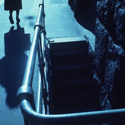 En ensam kvinna går på en mörk gata