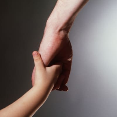 Barn och vuxen hand i hand.