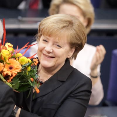 Angela Merkel vastaaottaa kukat parlamentissa tultuaan valituksi kolmannelle kaudelleen liittokanslerina.