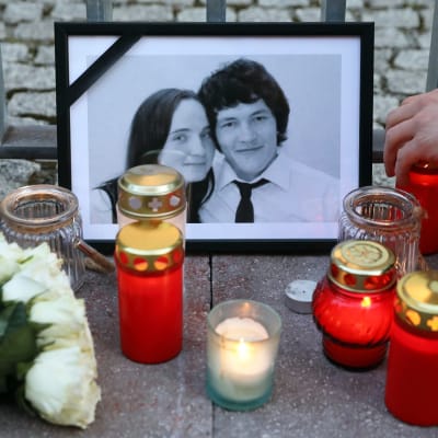 Ján Kuciakin ja Martina Kušnírován mustakehyksinen valokuva, jonka ympärille on tuotu kynttilöitä.