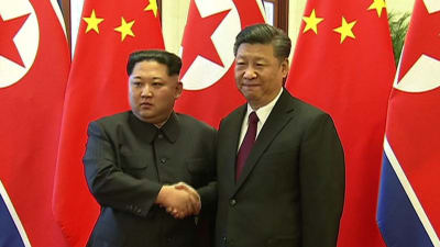 Ett handslag mellan Nordkoreas ledare Kim Jong-Un och Kinas president Xi Jinping inför kinesisk tv i Peking på tisdagen den 27.3.