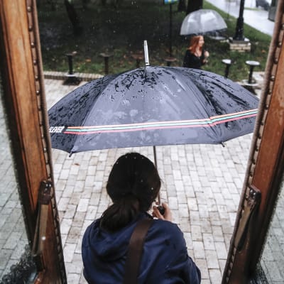 Nainen astuu ulos sateeseen Kiovassa, Ukrainassa.