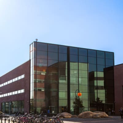Bild på yrkesinstitutet Prakticums fasad, rött stenhus med stor glasvägg.
