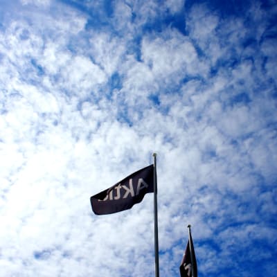 en flagga med banknamn, moln i bakgrunden.