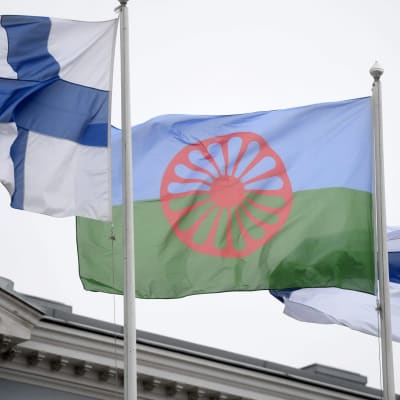 Romanien ja Suomen liput liehuvat salossa. Vuonna 1971 Lontoossa pidettiin ensimmäinen kansainvälinen romanikongressi ja hyväksyttiin romanien lippu. 