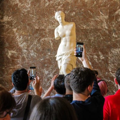 Turisteja katsomassa Milon Venus -veistosta Louvressa.