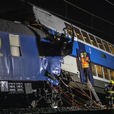 Pelastuslaitoksen työntekijöitä tarkistivat turmajunan vaunua yöllä lähellä Prahaa. jät olivat illal