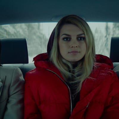 Aurora mellan Darian och dennes hustrukandidat i baksätet på en bil.