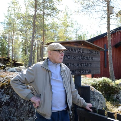 Pentti Kronqvist står framför en gammal träkyrka. 