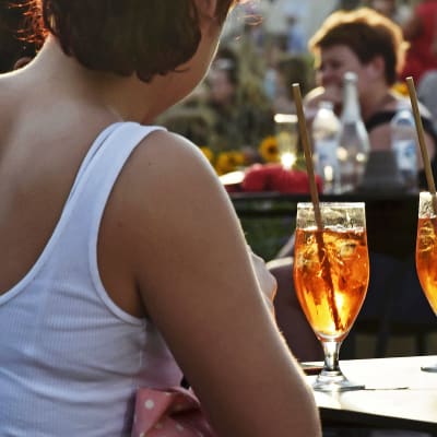 Ihmisiä drinkkeineen terassilla.