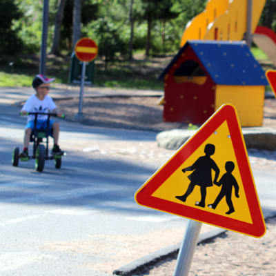 Pieniä lapsia leikkimässä lapsille rakennetulla liikennealueella.