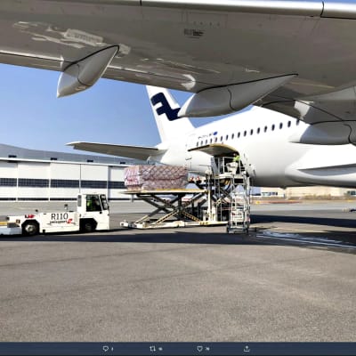 Bild på vitt Finnair-flygplan. På bilden lastas materiel ut ur planet. 