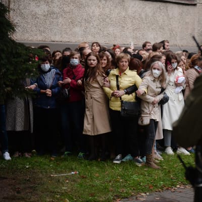 Kuvassa Minskissä on rykelmä naisia, etualalla seisoo tumma poliisihahmo.