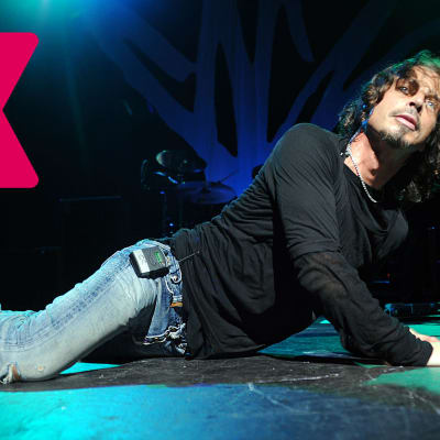 Chris Cornell ligger ner på scenen och lutar sig mot ena armen med huvudet höjt.