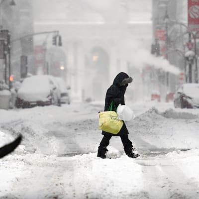 Henkilö kävelee lumimyräkässä New Yorkissa.