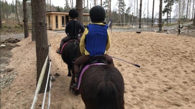 barn som rider på hästar.