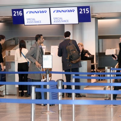 Matkustajia lähtöselvityksessä Finnairin Los Angelesiin lähdössä olevalle lennolle Helsinki-Vantaan lentoasemalla