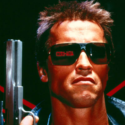 Arnold Schwarzenegger ase kädessä lähikuvassa tuhoajarobottina elokuvassa Terminator.