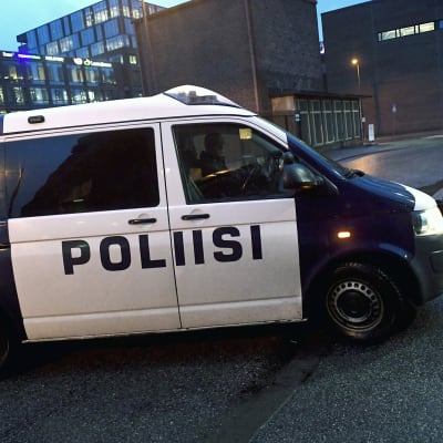 Poliisiauto ajaa oikeustalon portille Helsingissä.