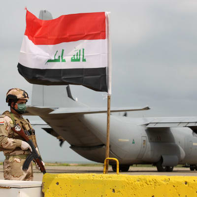 Sotilas seisoo Irakissa Yhdysvaltain lentokoneen edustalla.