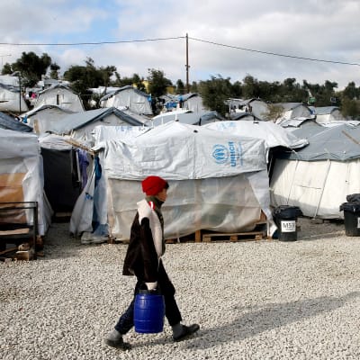 Lapsi kantaa vesitynnyriä Morian pakolaisleirillä Kreikassa.