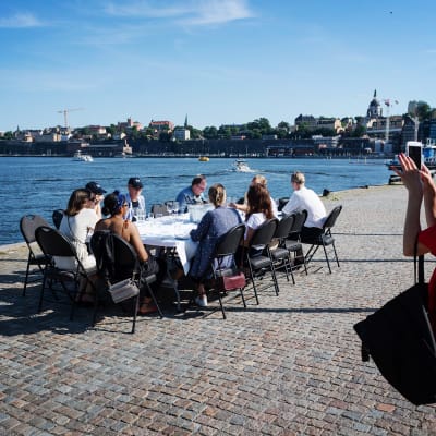 Kuvassa nainen ottaa kuvaa seurueestaan Tukholmassa.