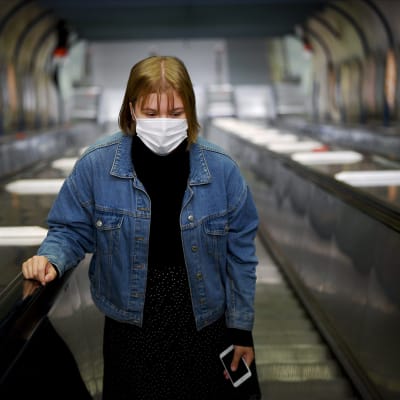 Hengityssuojainta käyttävä nainen Ruoholahden metroasemalla Helsingissä 4. elokuuta 2020.