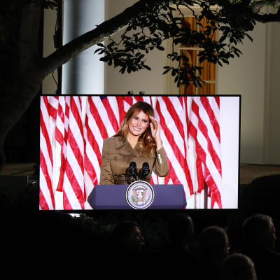 Melania Trump kuvattuna Valkoisen talon puutarhassa sijaitsevan näytön ruudulta..