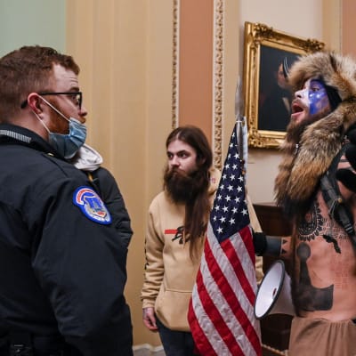 Mielenosoittaja puhuu vartijalle Yhdysvaltain kongressitalossa Washington DC:ssä.