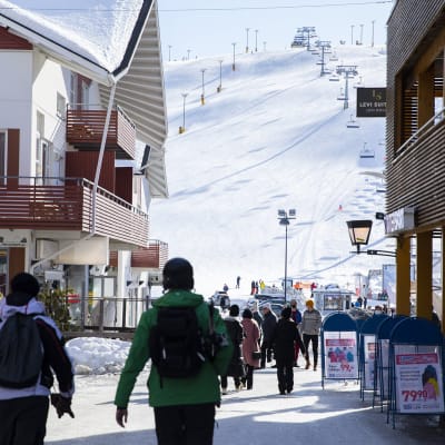 Matkailijoita Levin laskettelu- ja hiihtokeskuksessa Kittilässä aurinkoisena kevättalven päivänä 25. maaliskuuta 2021.