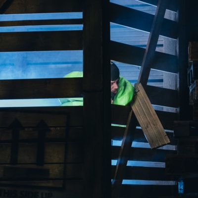 Käärijä, klädd i grönt, uppträder på en scen, inne i en stor trälåda.