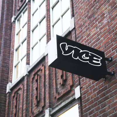 Vice-verkkomedian kyltti kiinnitettynä punatiilisen rakennuksen seinään.