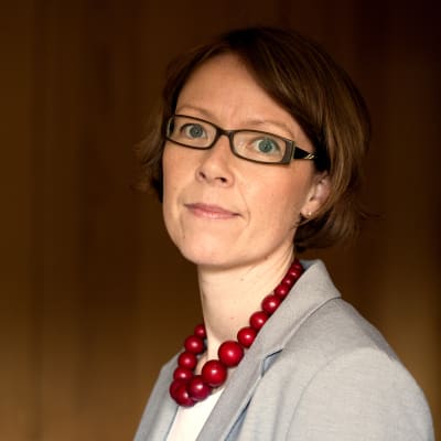 Cataharina Groop poserar framför en brun bakgrund.