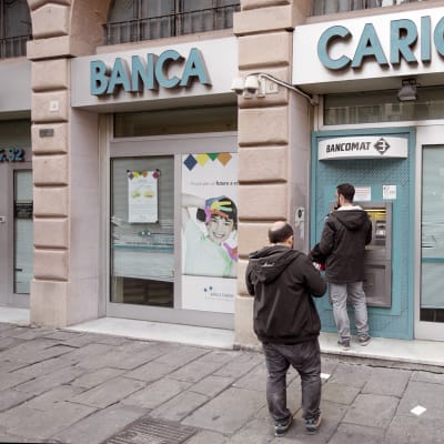 Asiakkaat jonottavat pankkiautomaatille Italian Genovassa.