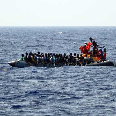 Kuvassa on vene täynnä siirtolaisia Välimerellä.